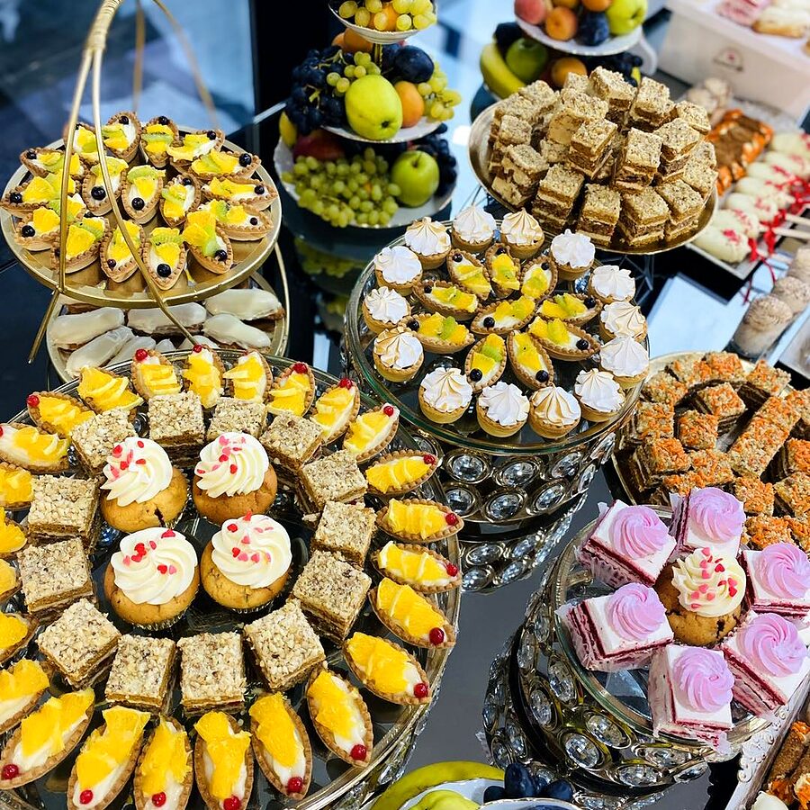 Candybar cu prăjituri galbene și crem, pe etajere de sticlă